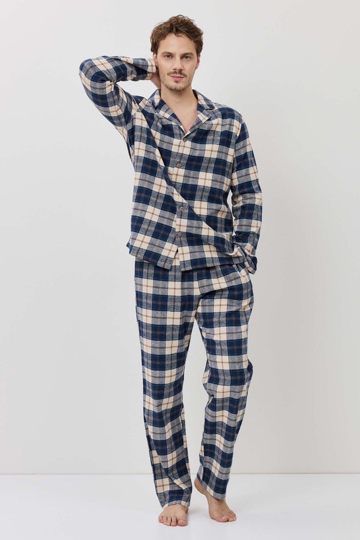 Man wearing a blue and white checkered pajama set on a white background