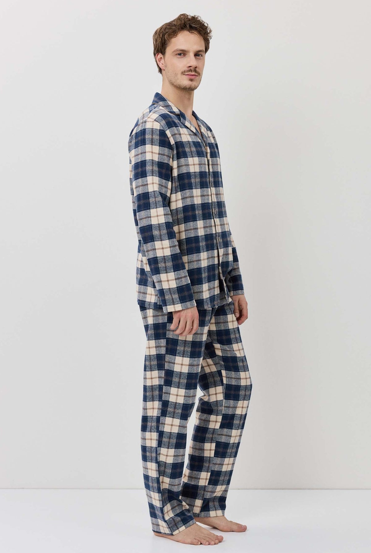 Man wearing a blue and beige plaid pajama set on a white background