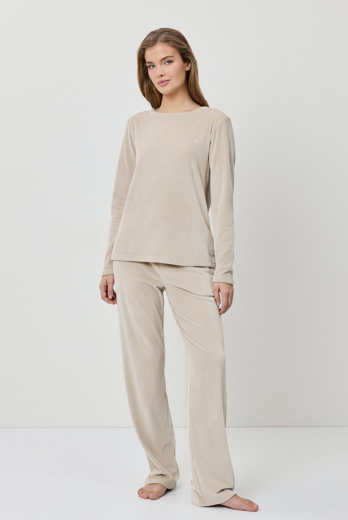 Woman wearing a beige loungewear set on a white background