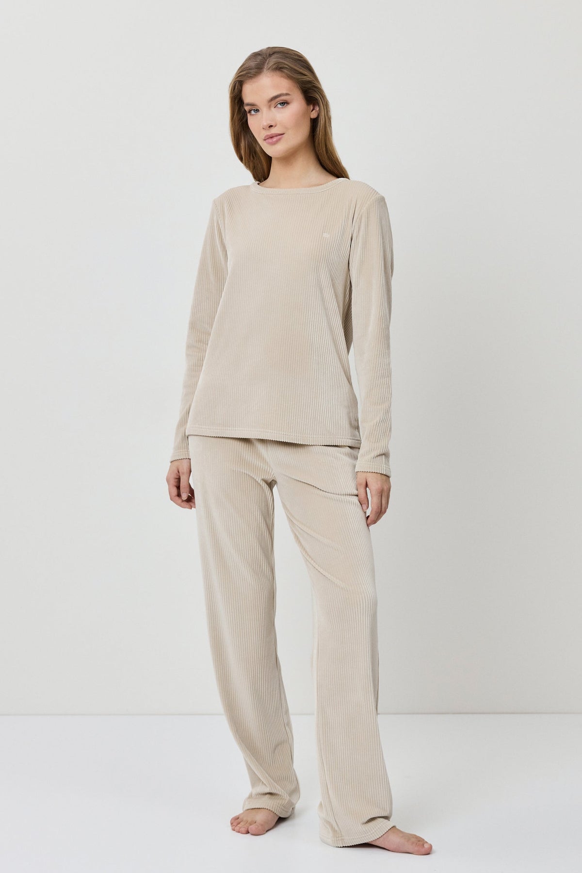Woman wearing a beige loungewear set on a white background