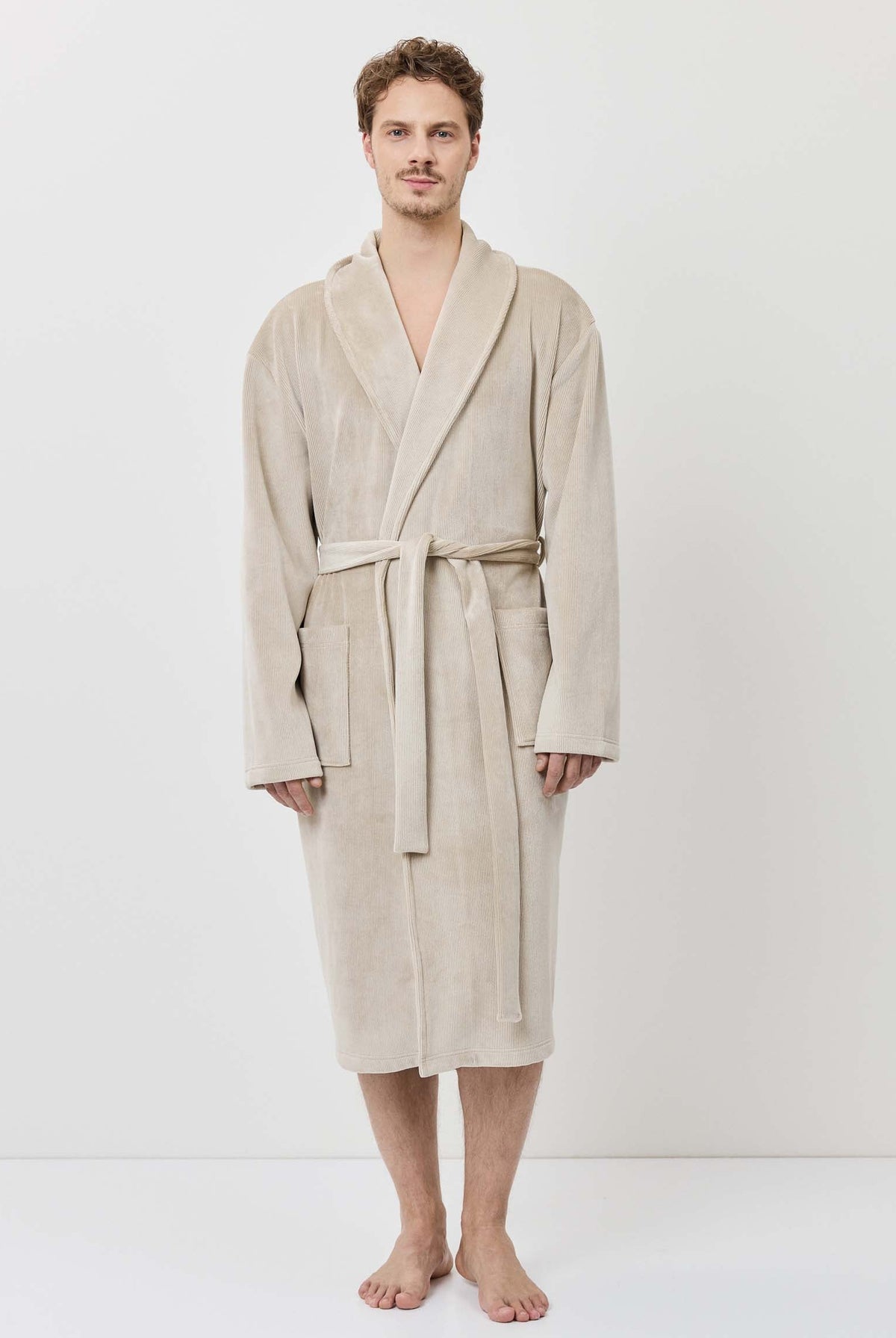 Man wearing a beige robe against a white background