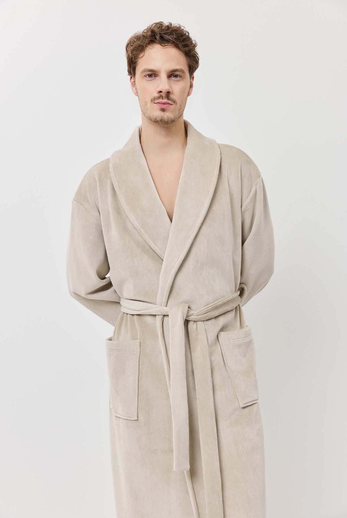 Man wearing a beige robe against a white background