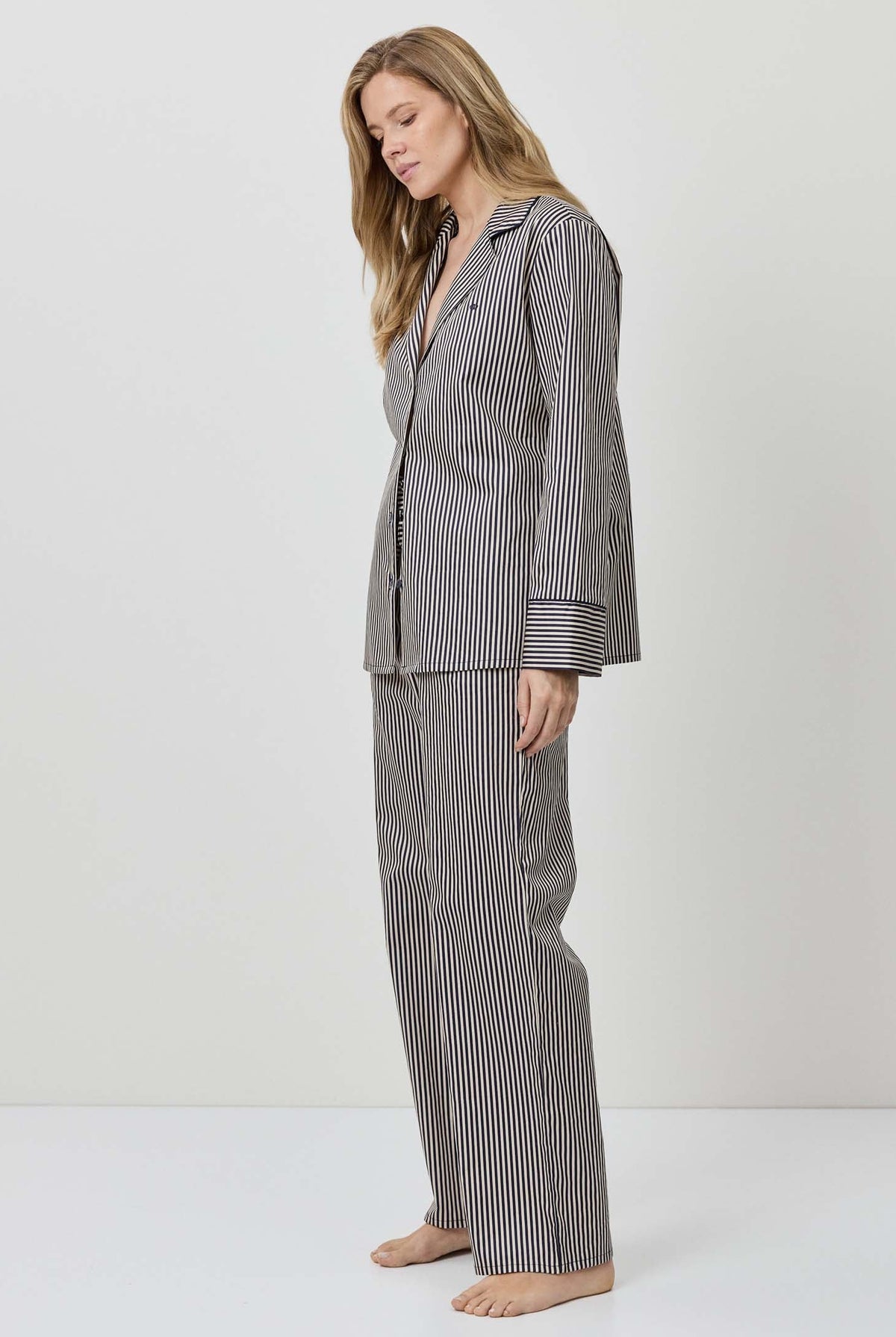 Woman wearing a gray striped pajama set on a white background