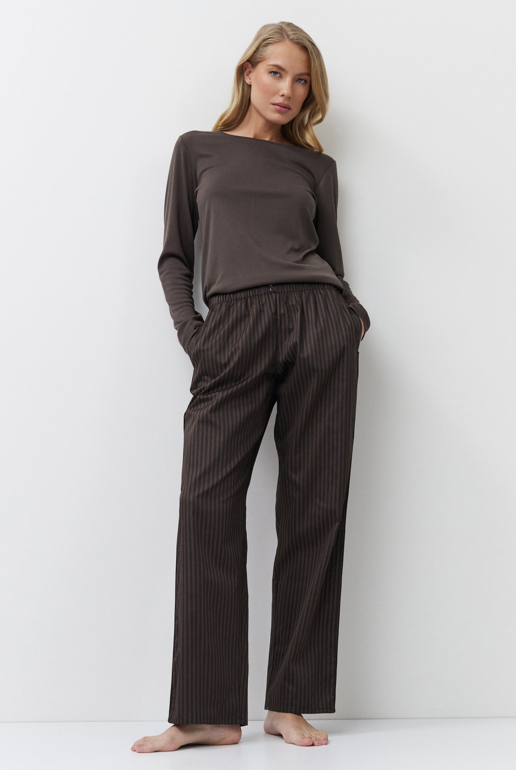 Woman wearing a brown outfit with a plain white background