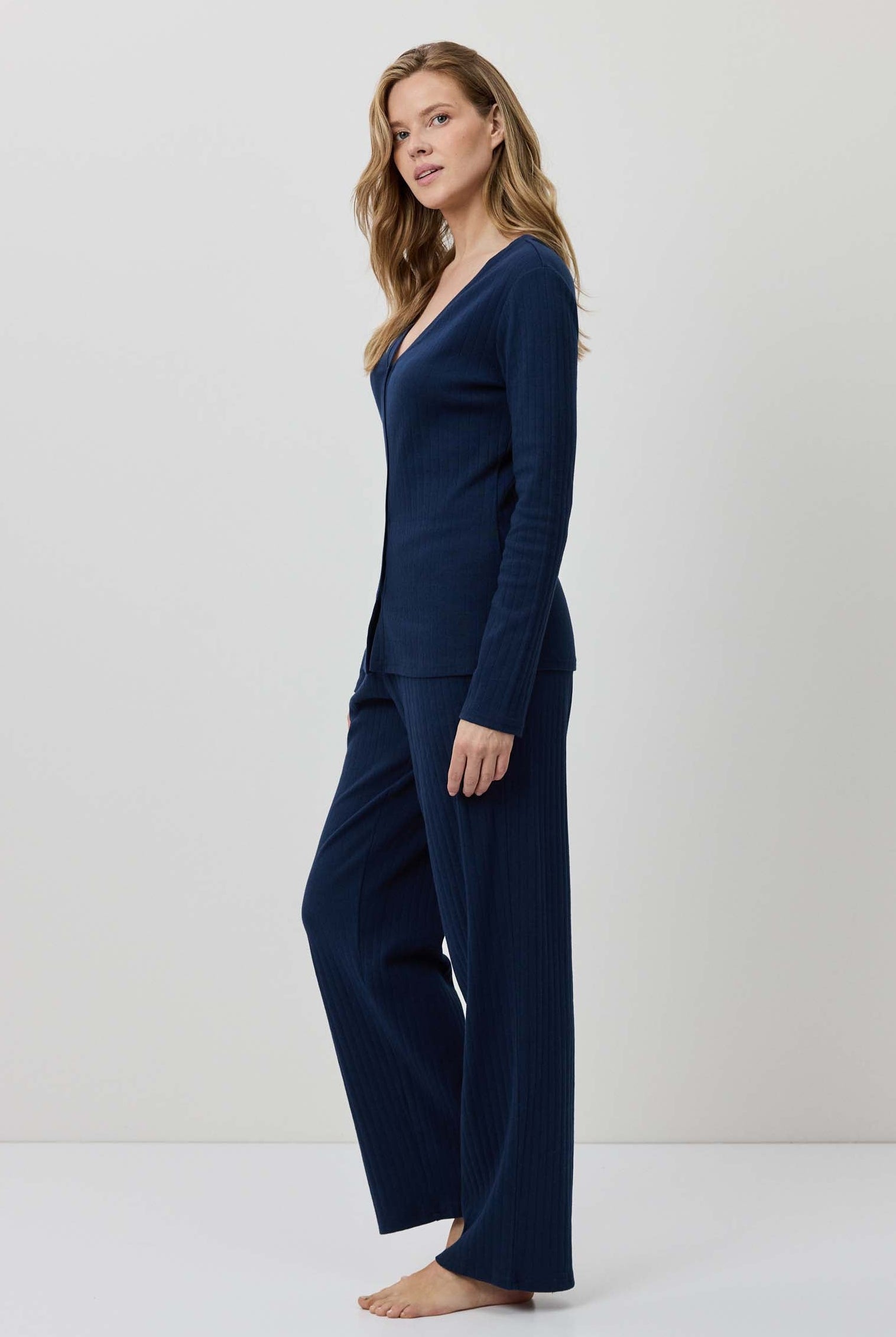 Woman wearing a navy blue outfit against a white background