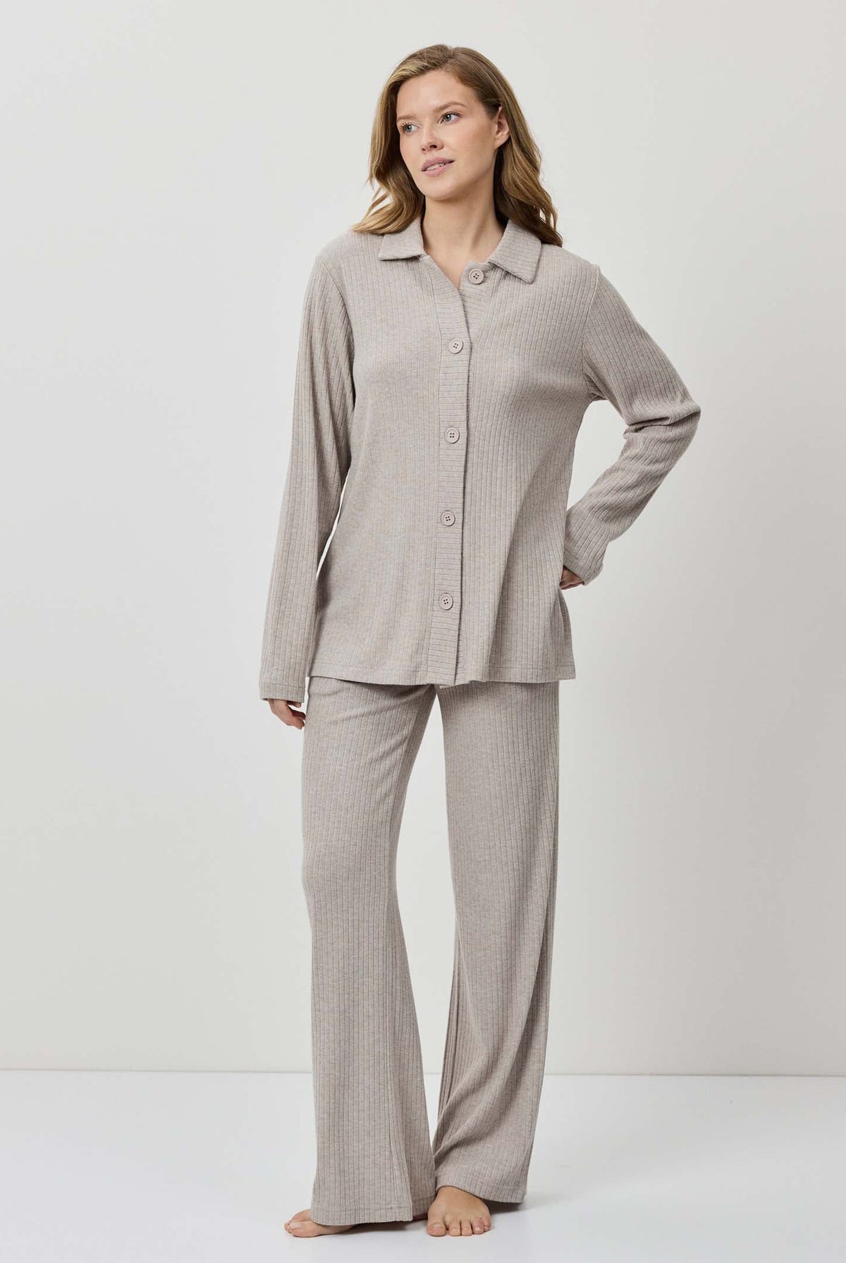 Woman wearing a gray pajama set on a white background