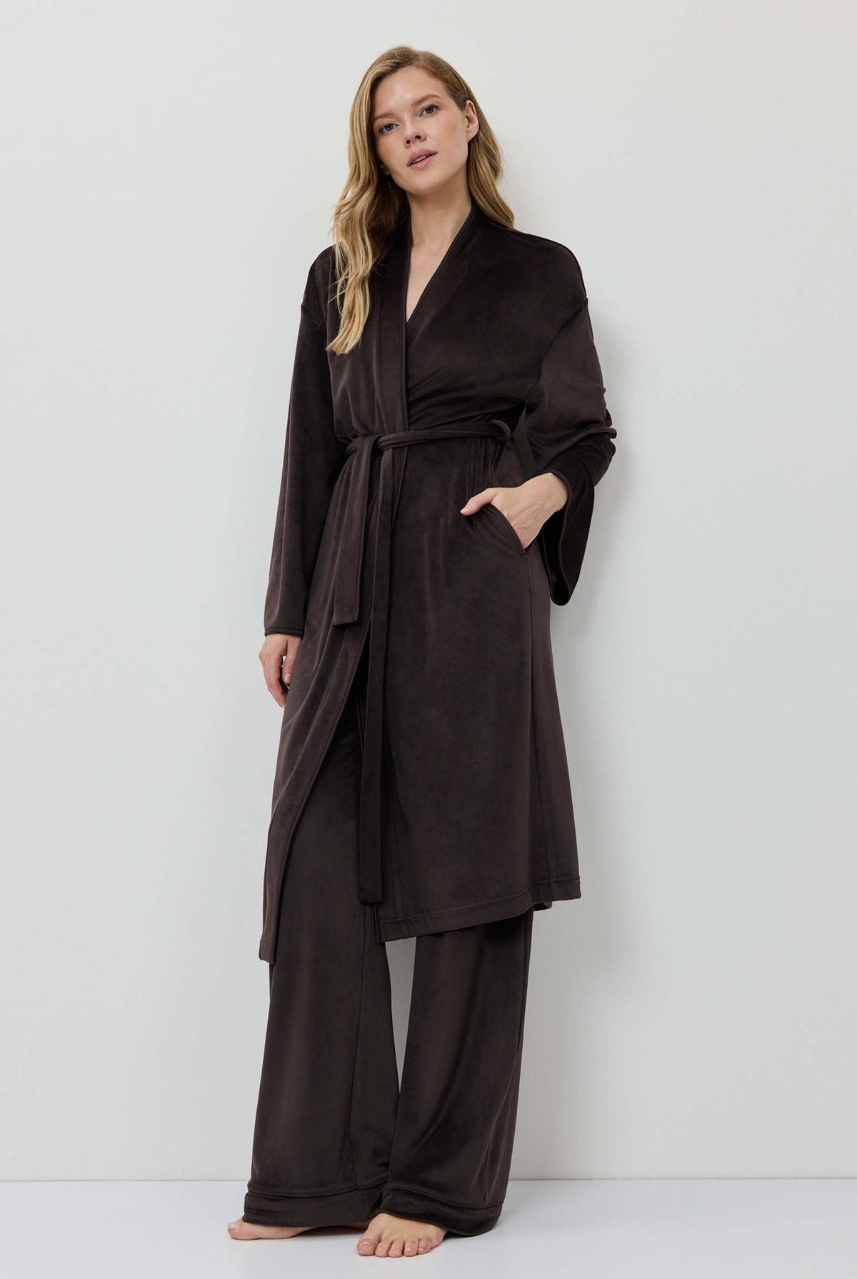 Woman wearing a dark brown robe against a white background