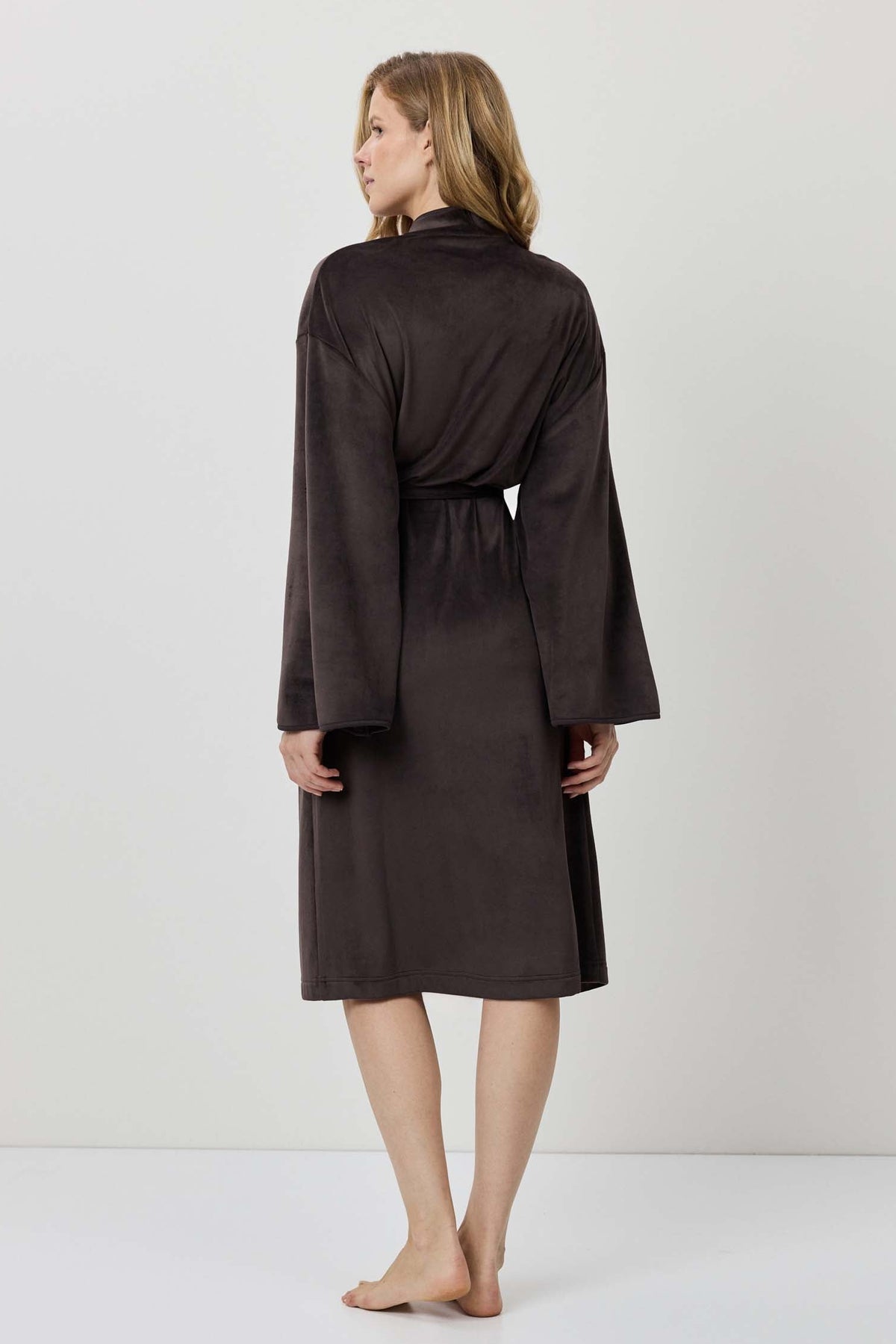 Woman wearing a black robe against a white background
