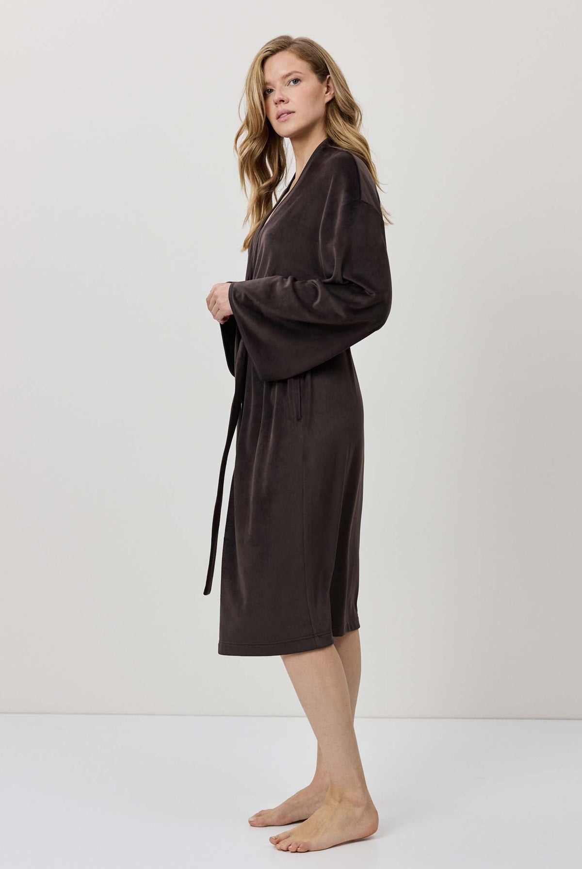 Woman wearing a brown robe against a white background