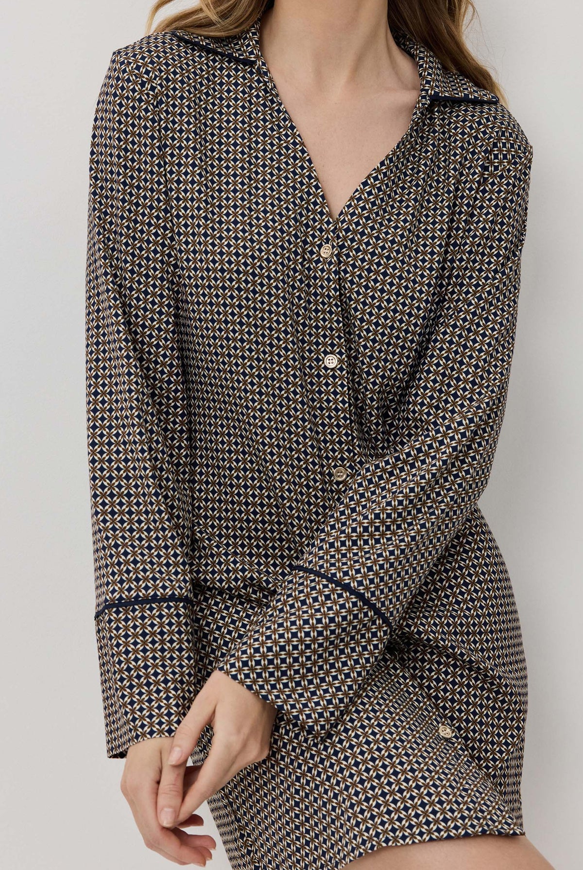 Woman wearing a houndstooth patterned outfit against a plain background