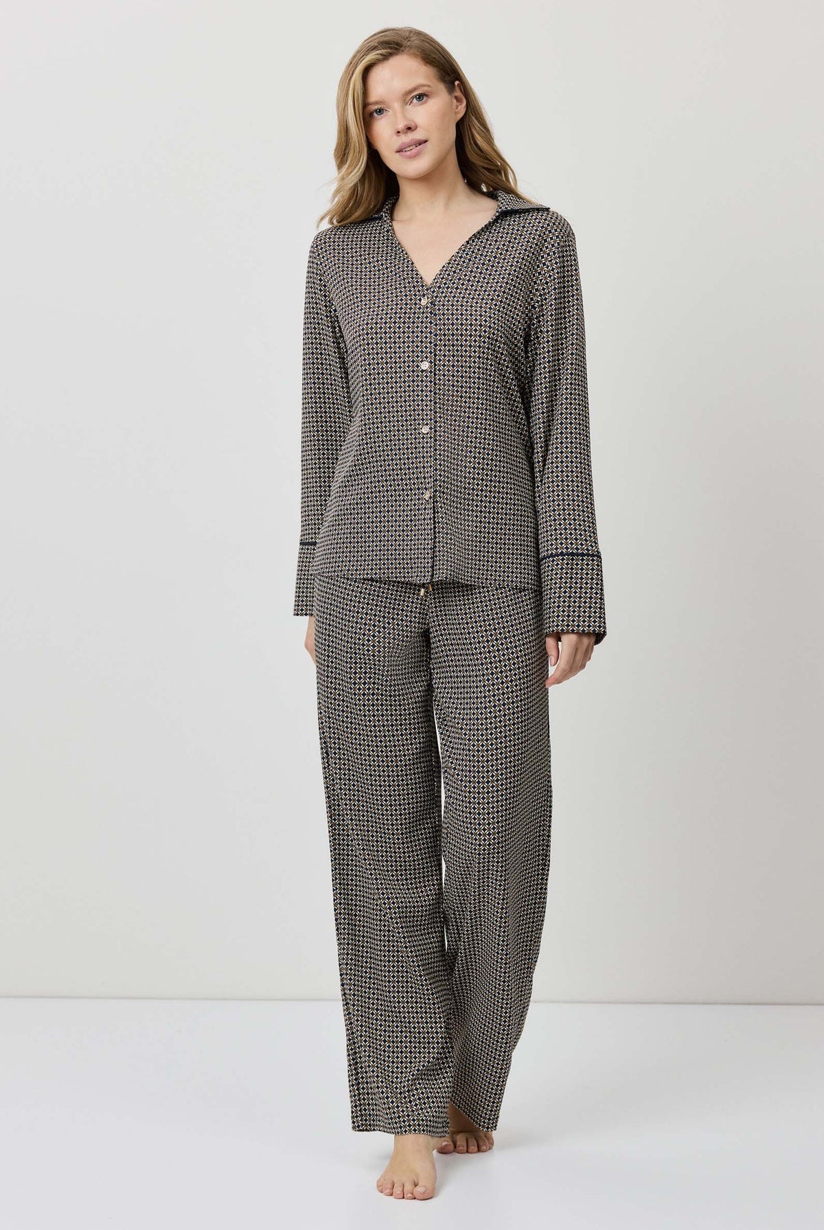 Woman wearing a gray checkered pajama set on a white background