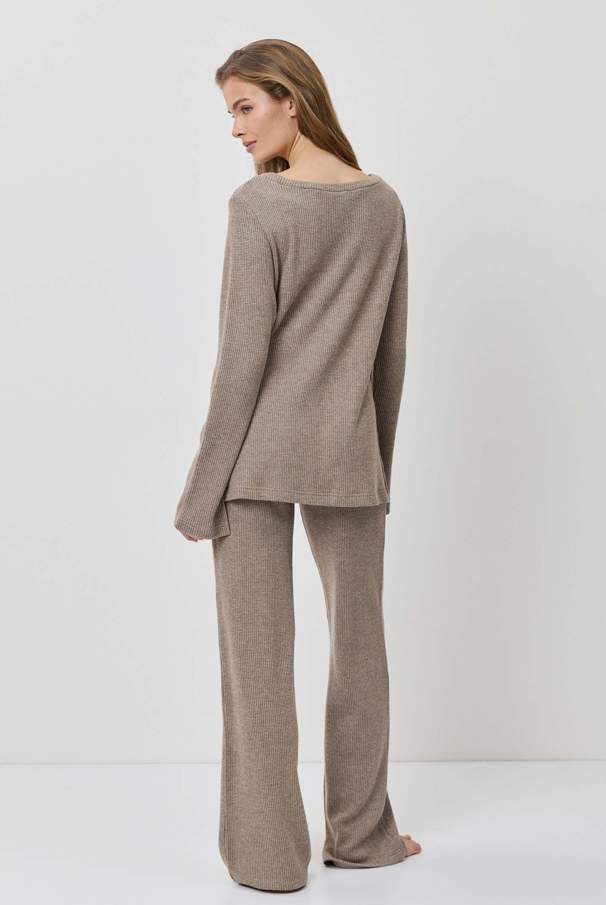 Woman wearing a brown outfit on a white background
