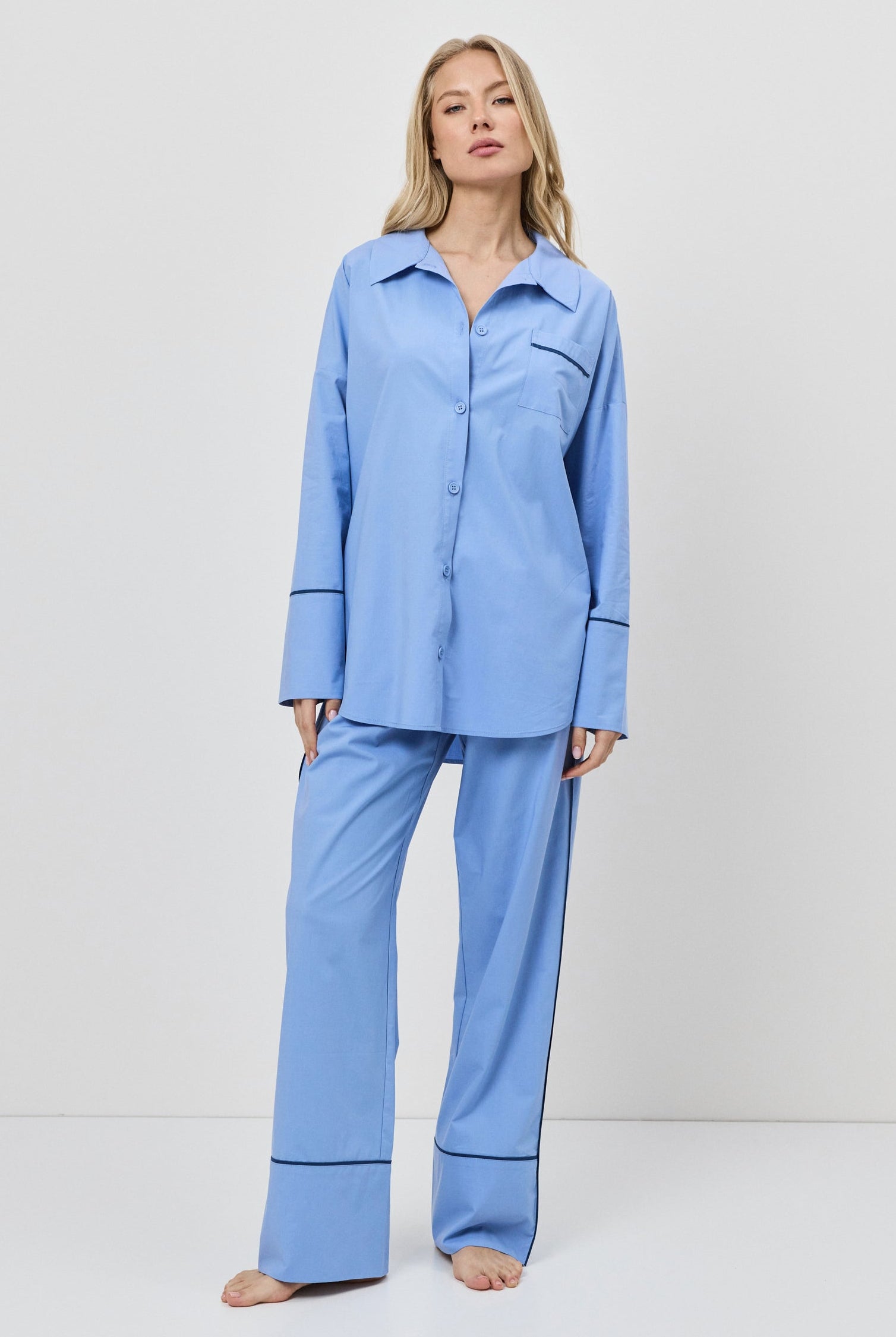 Woman wearing a blue pajama set against a white background