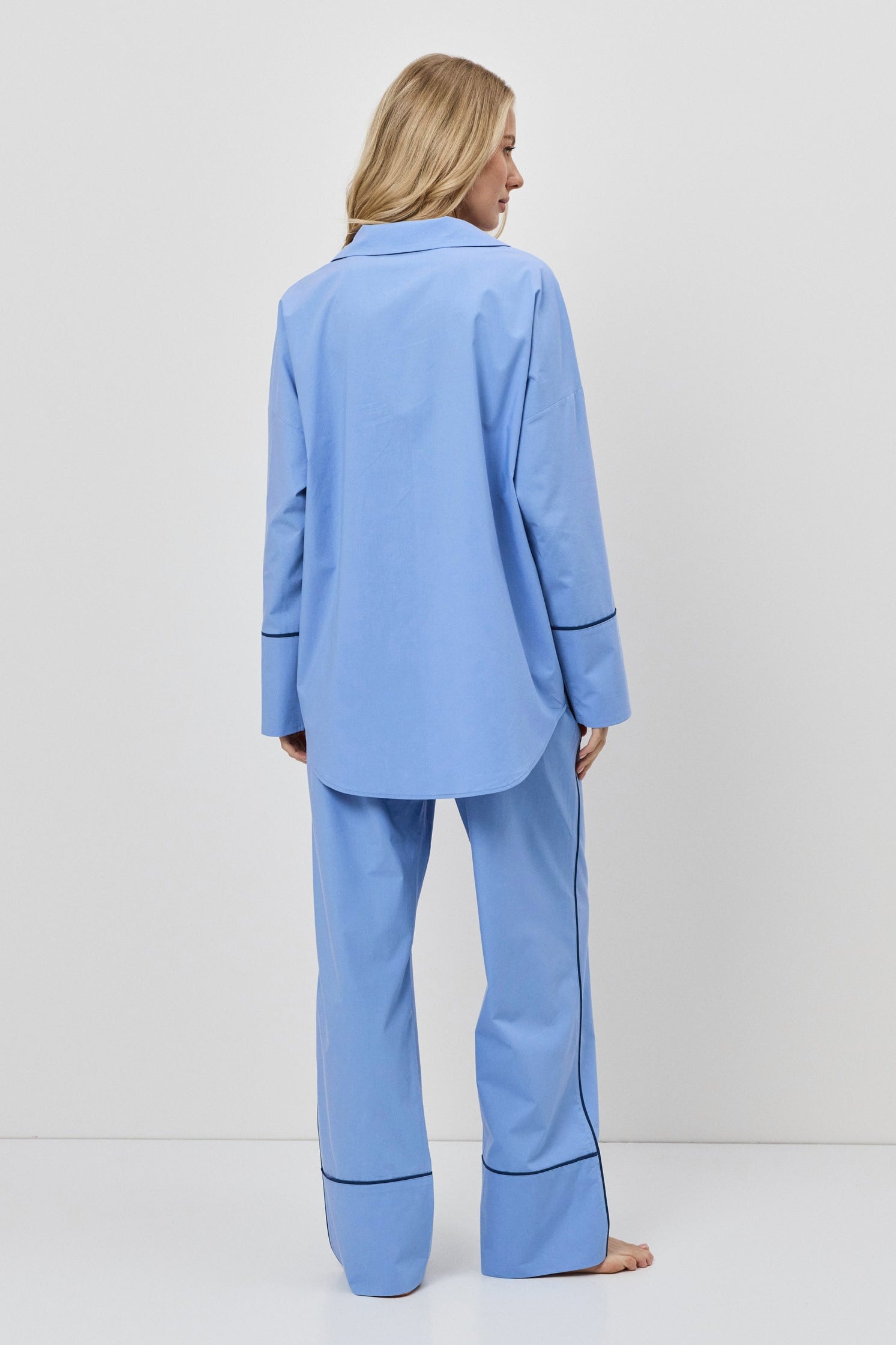 Person wearing a blue pajama set against a white background