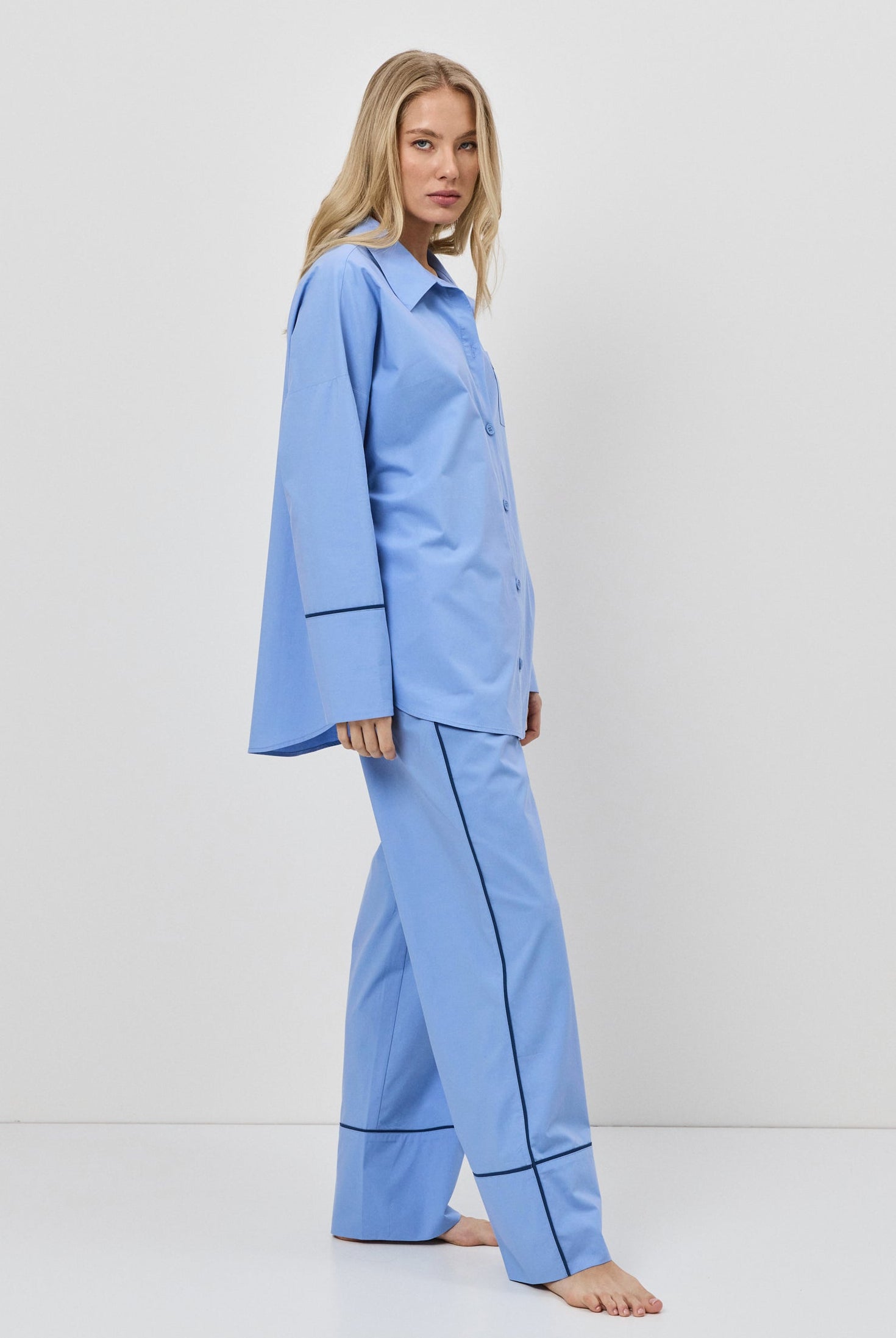 Woman wearing a blue pajama set against a white background
