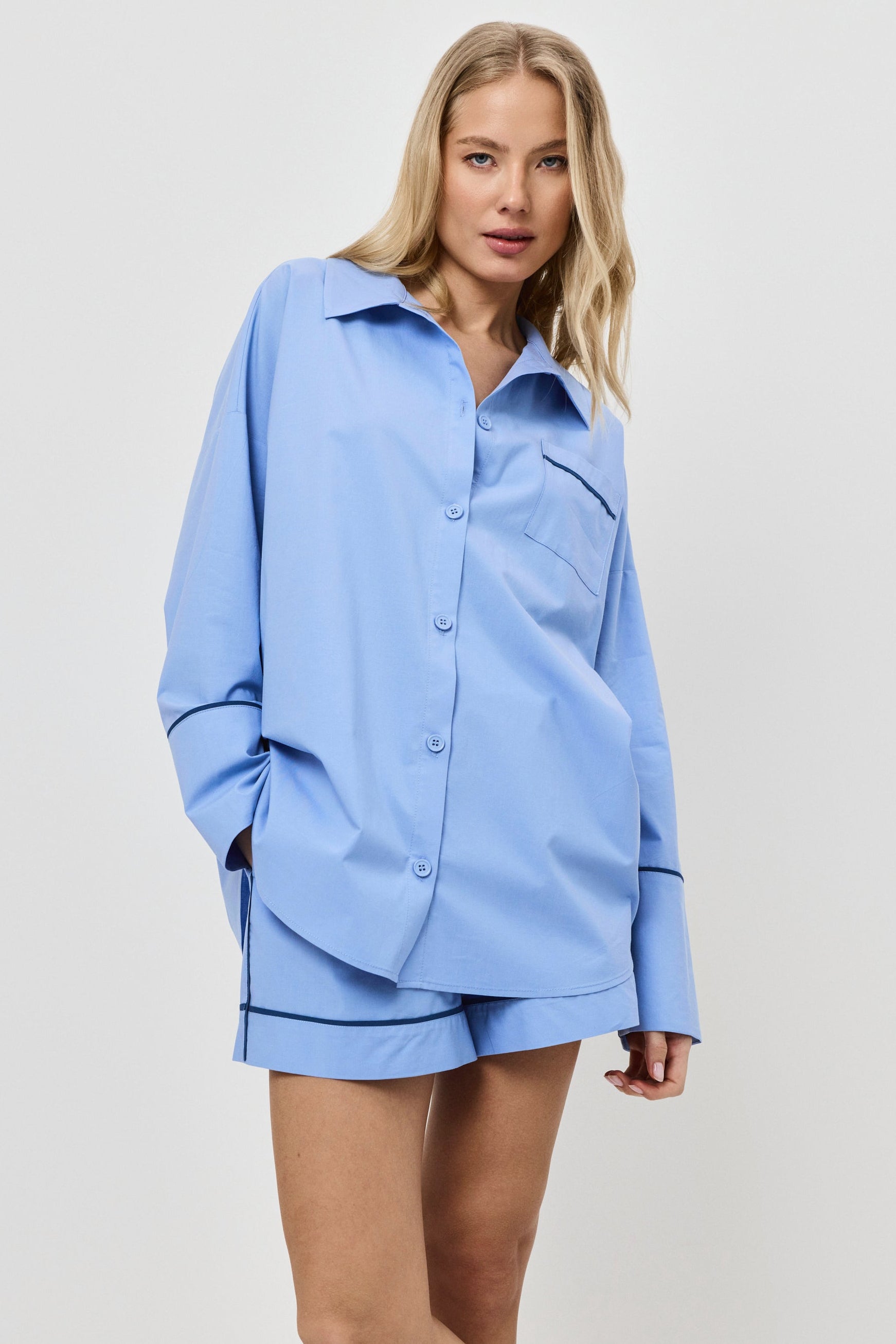Woman wearing a light blue pajama set on a white background