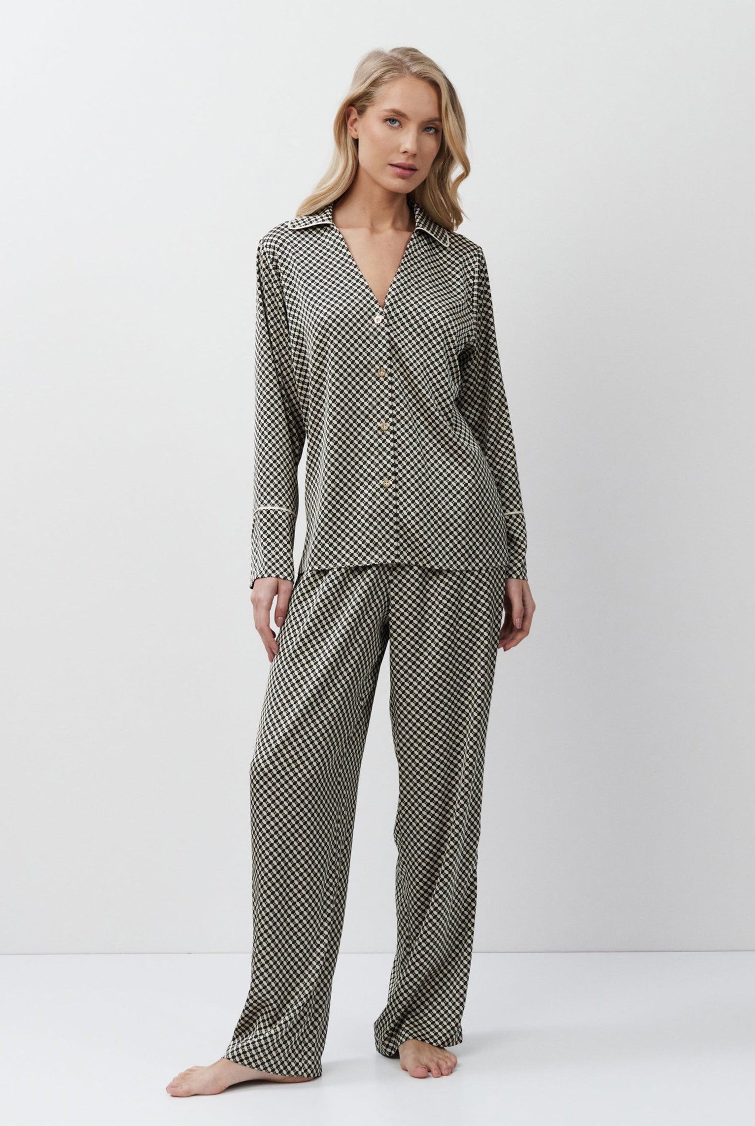 Woman wearing a patterned pajama set on a white background