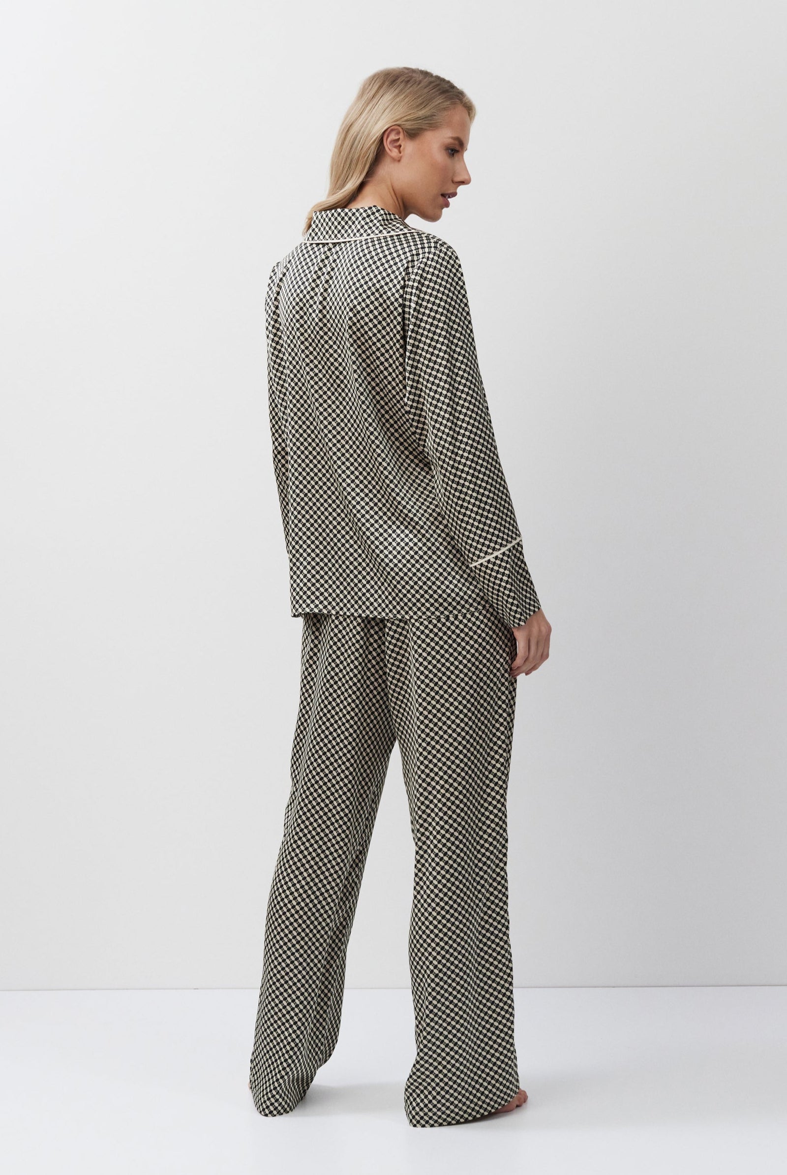 Woman wearing a patterned pajama set on a white background