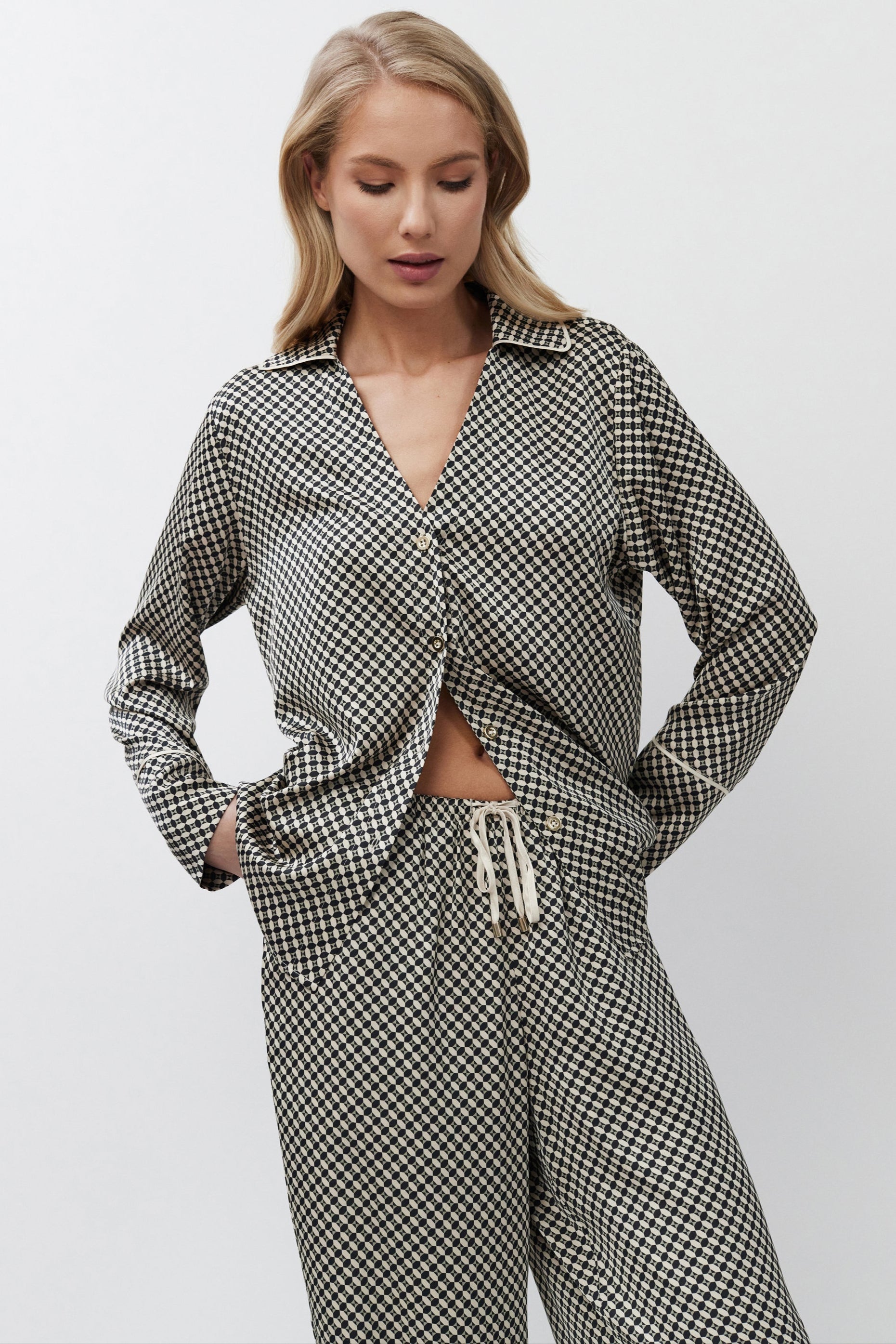 Woman wearing a patterned pajama set on a white background