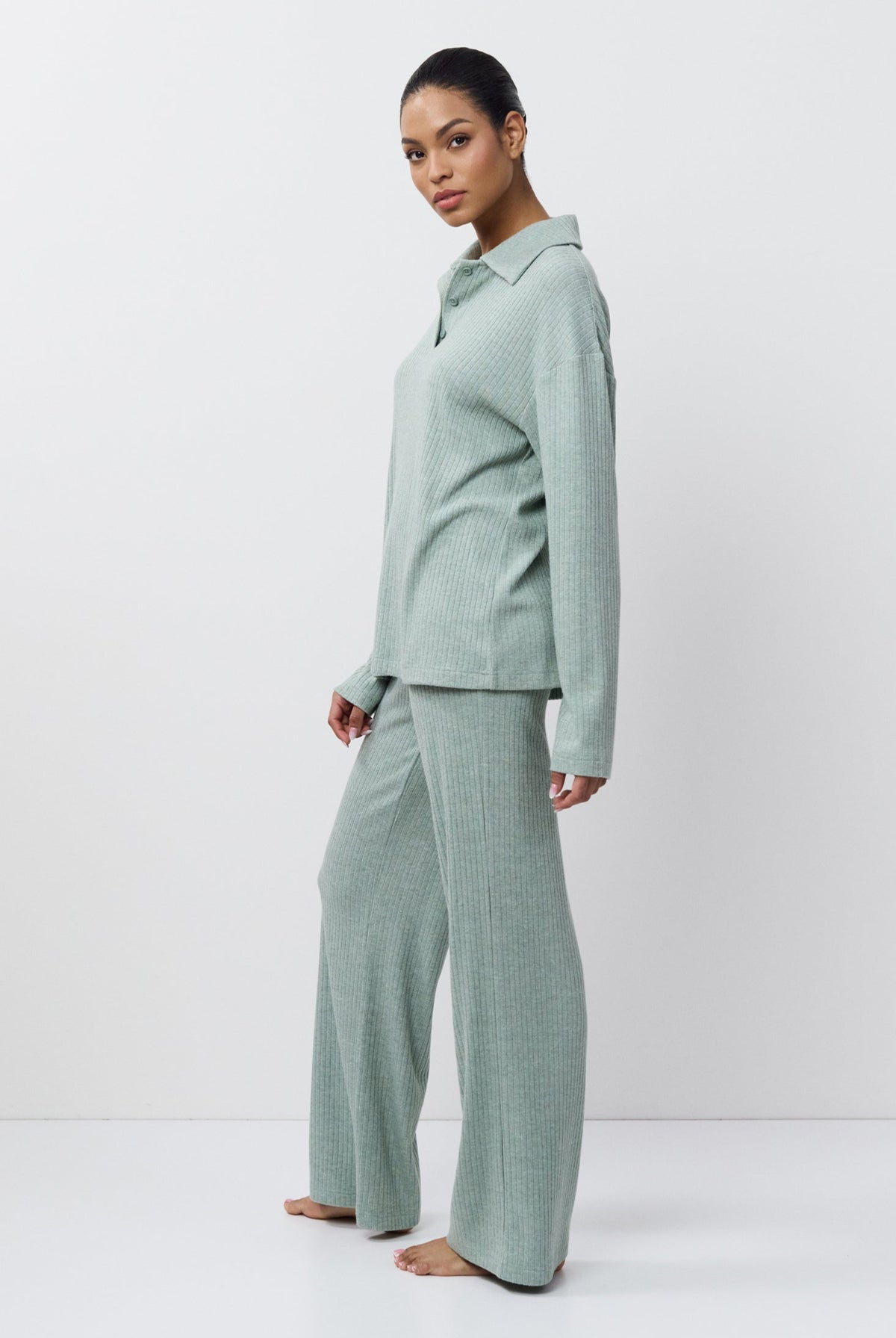 Person wearing a light green outfit on a white background