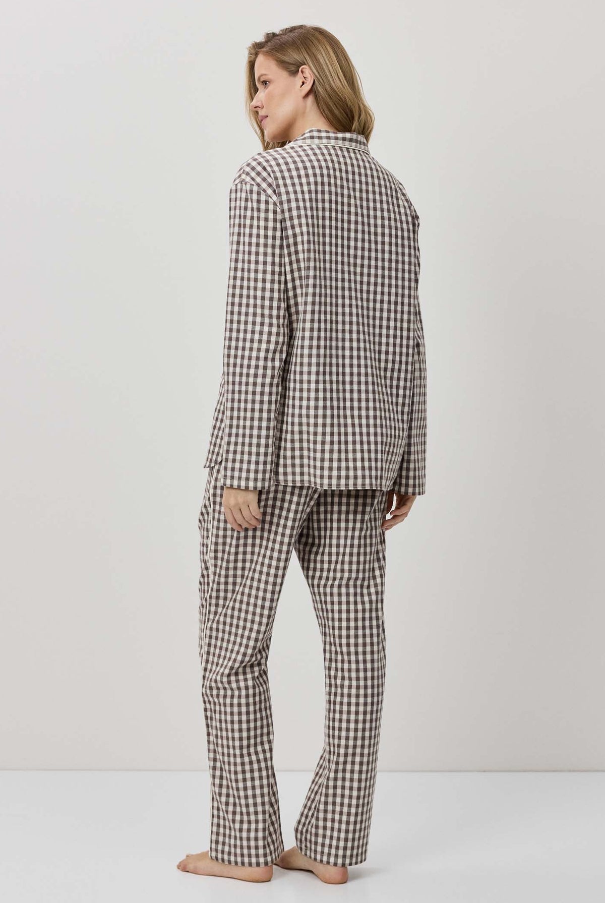 Person wearing a checkered pajama set on a plain background