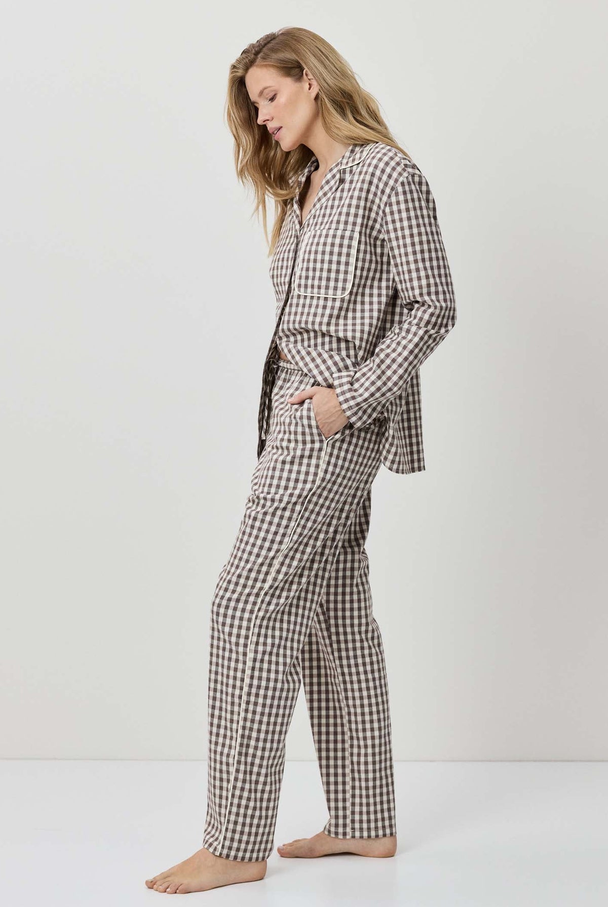Woman wearing a black and white checkered pajama set on a white background