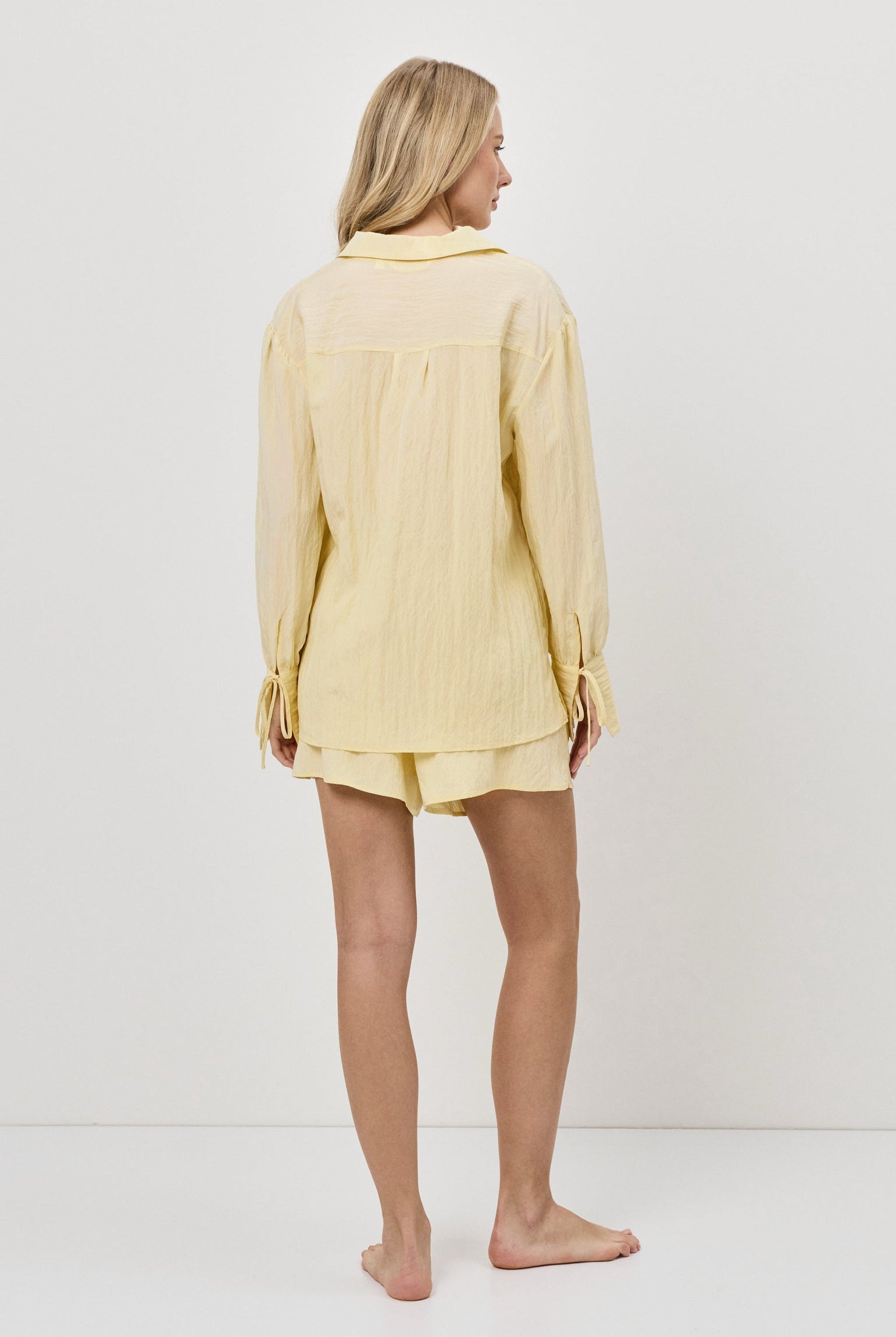 Woman wearing a yellow resort wear set on a white background