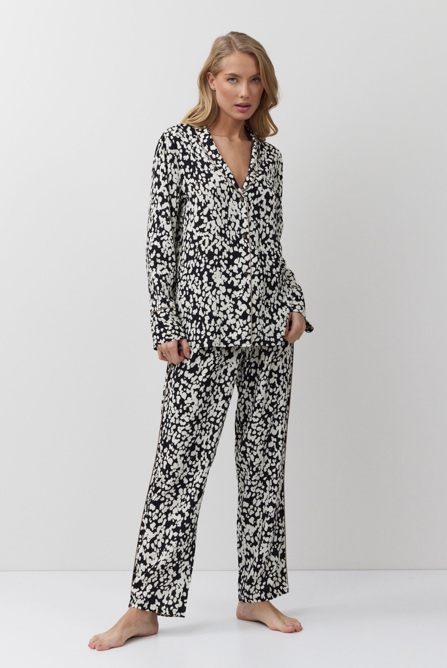 Woman wearing a black and white patterned pajama set on a white background