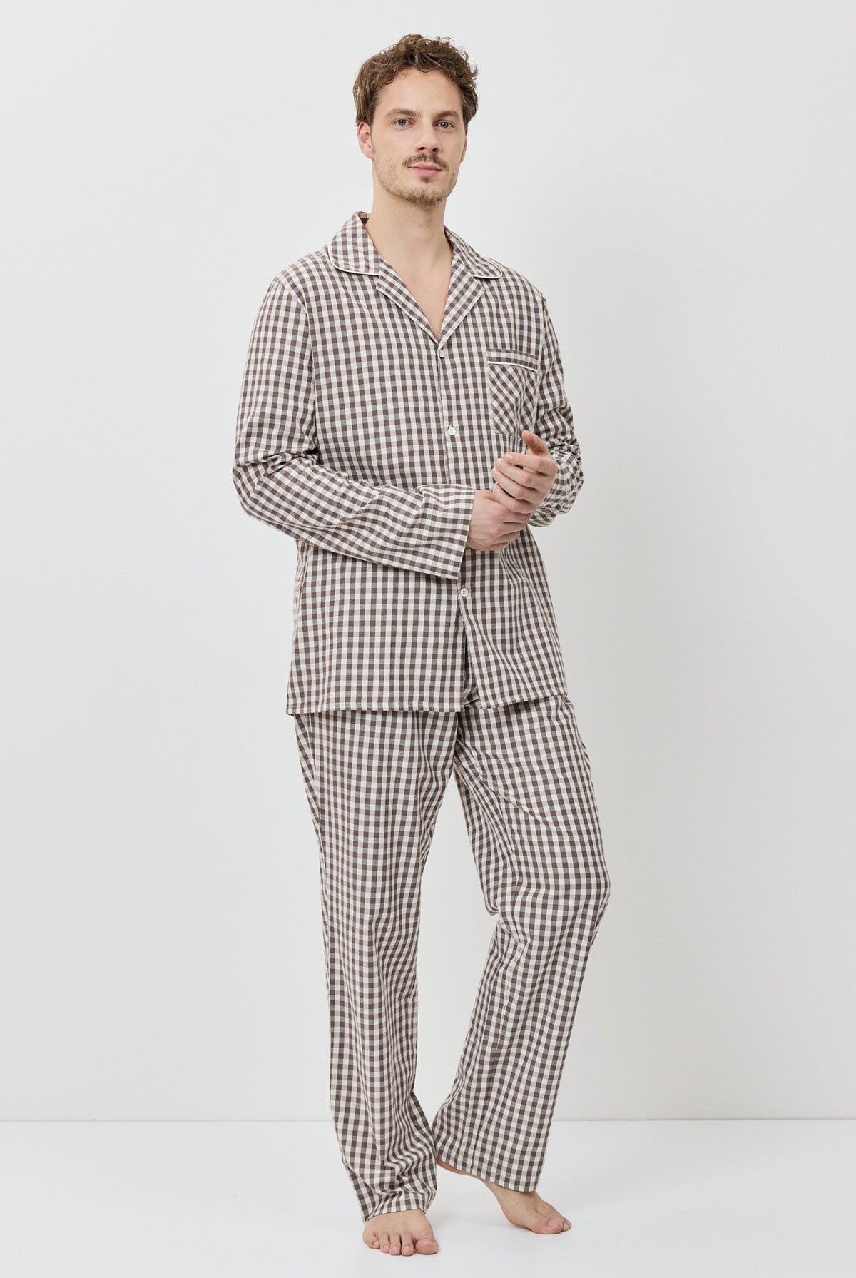Man wearing a checkered pajama set against a white background