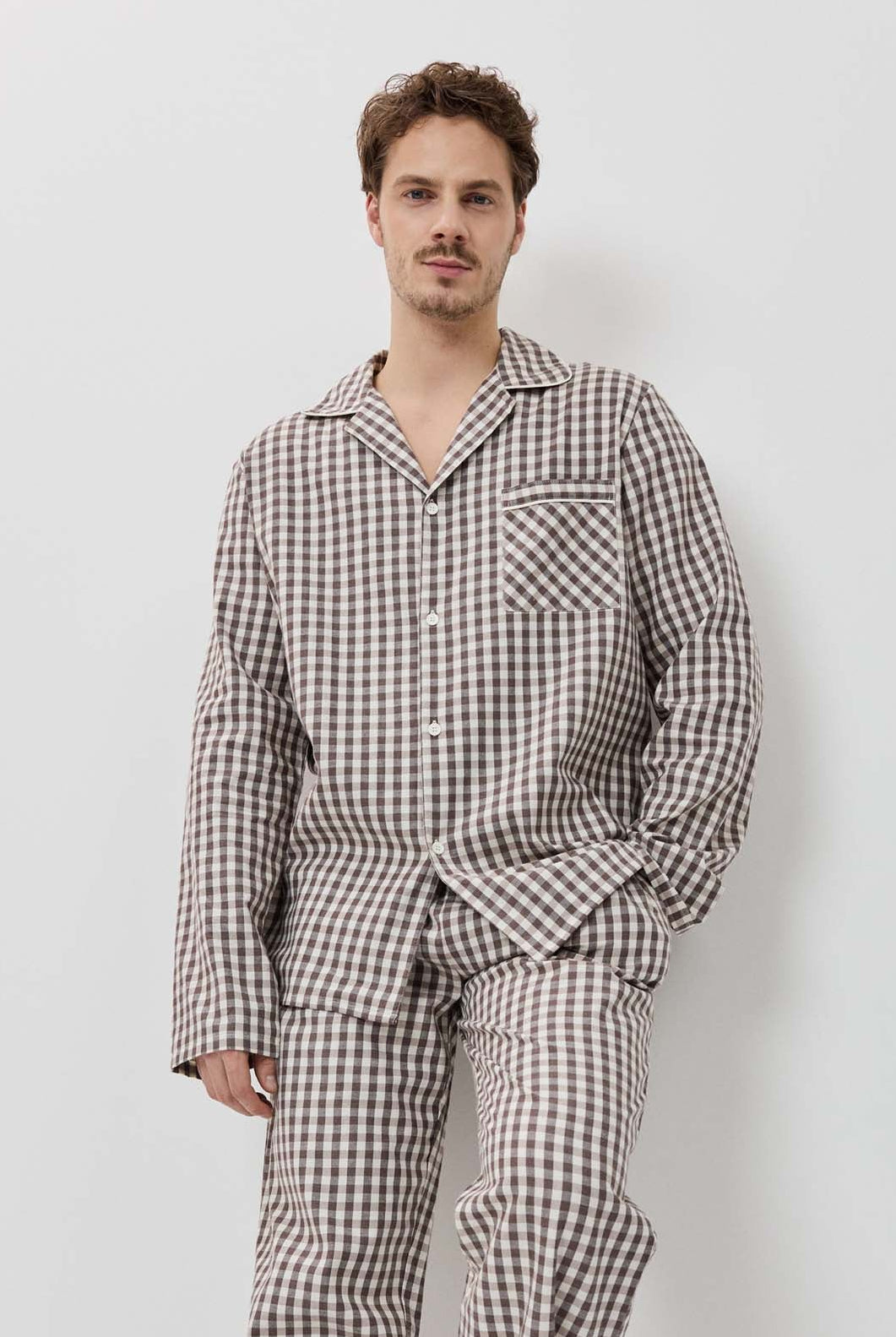 Man wearing a checkered pajama set against a white background