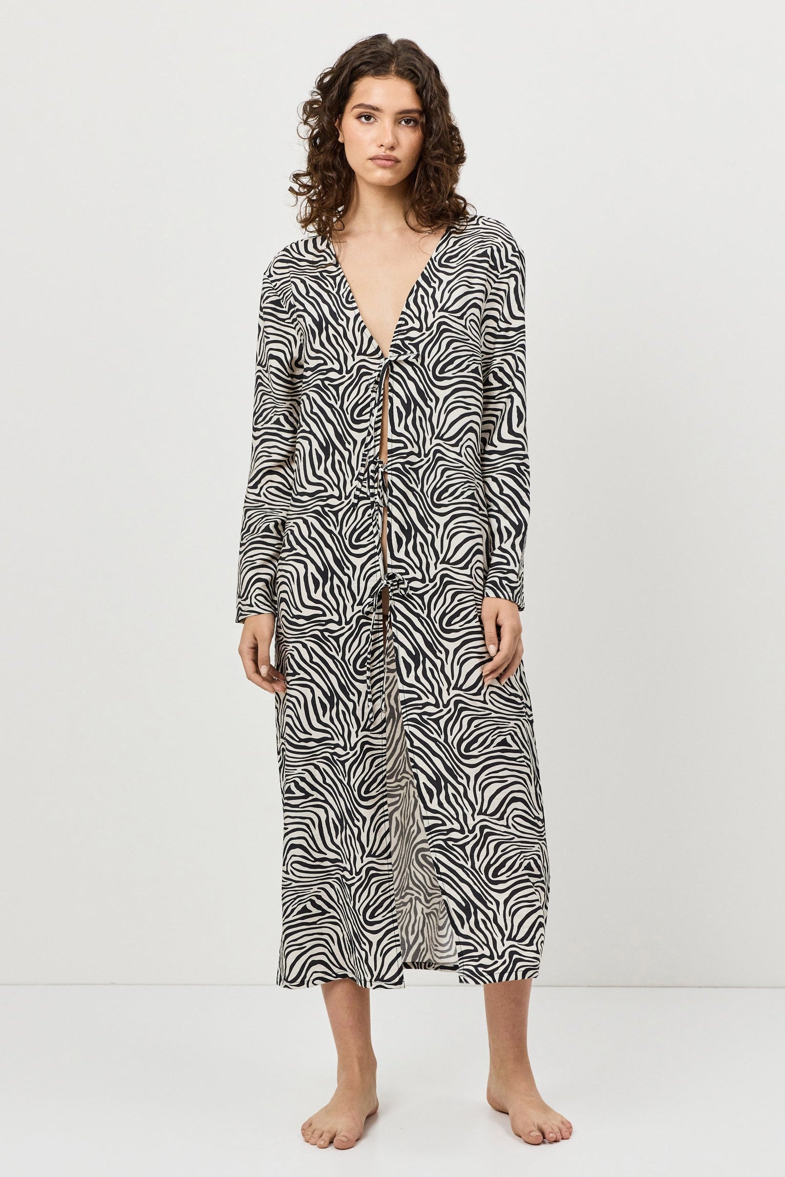 Woman wearing a patterned long dress on a white background