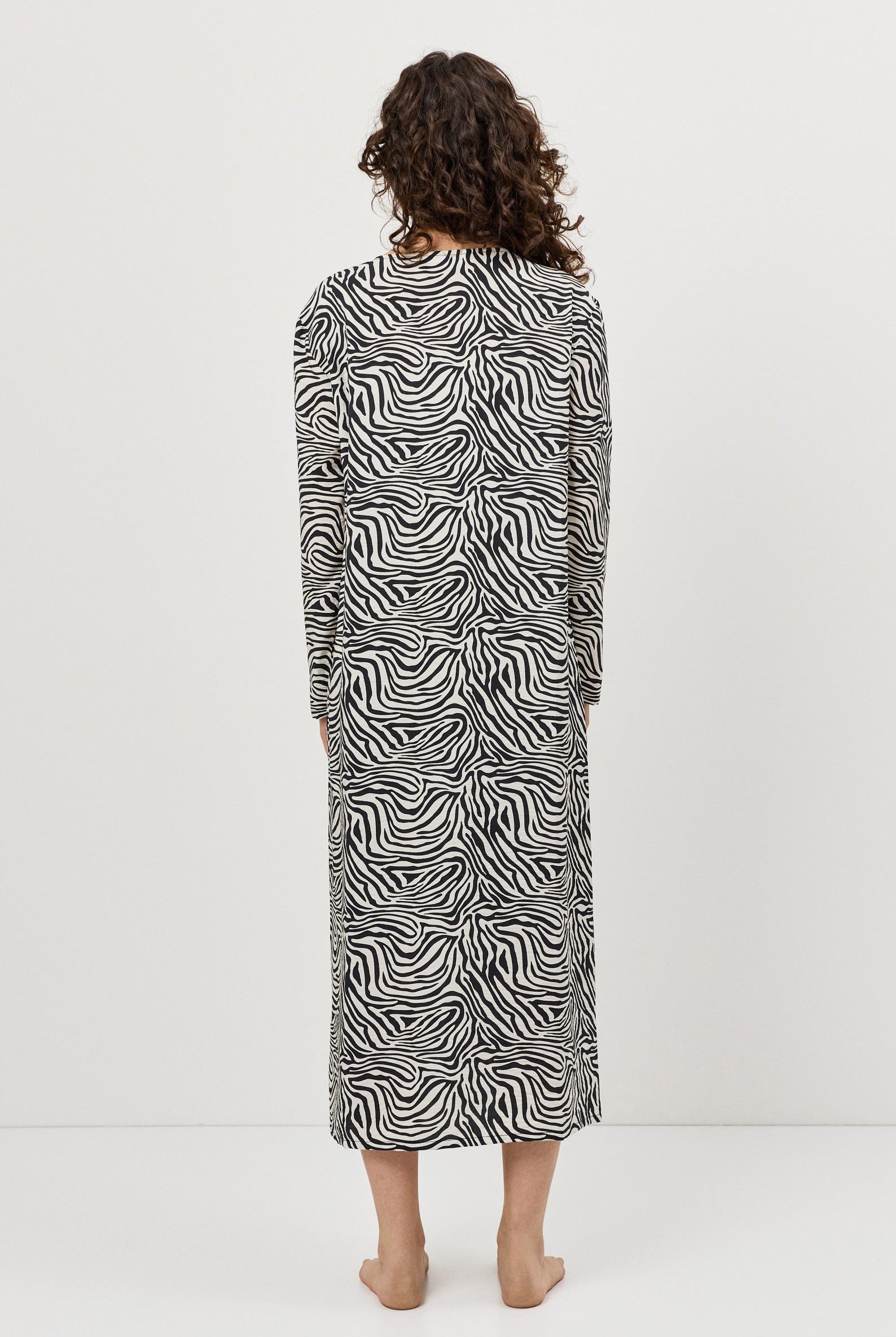 Person wearing a zebra print dress against a white background