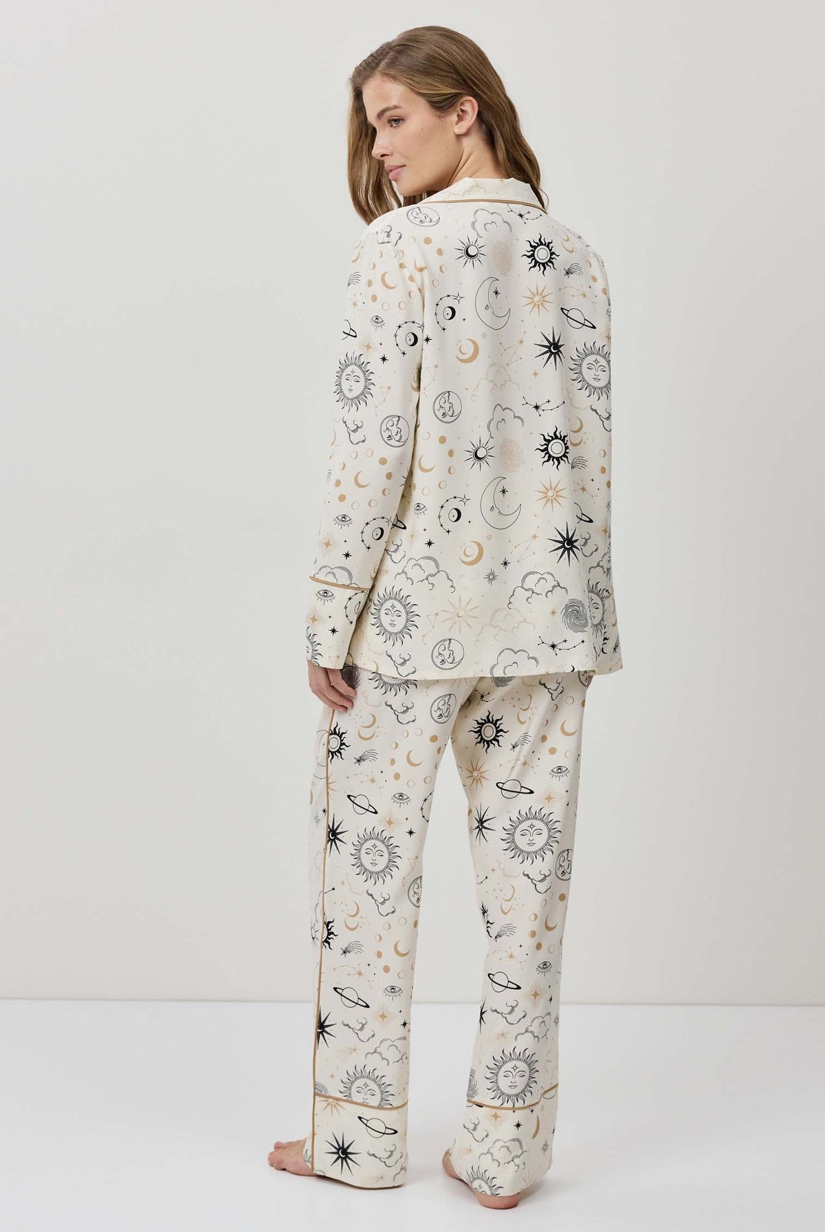 Person wearing a patterned pajama set on a white background