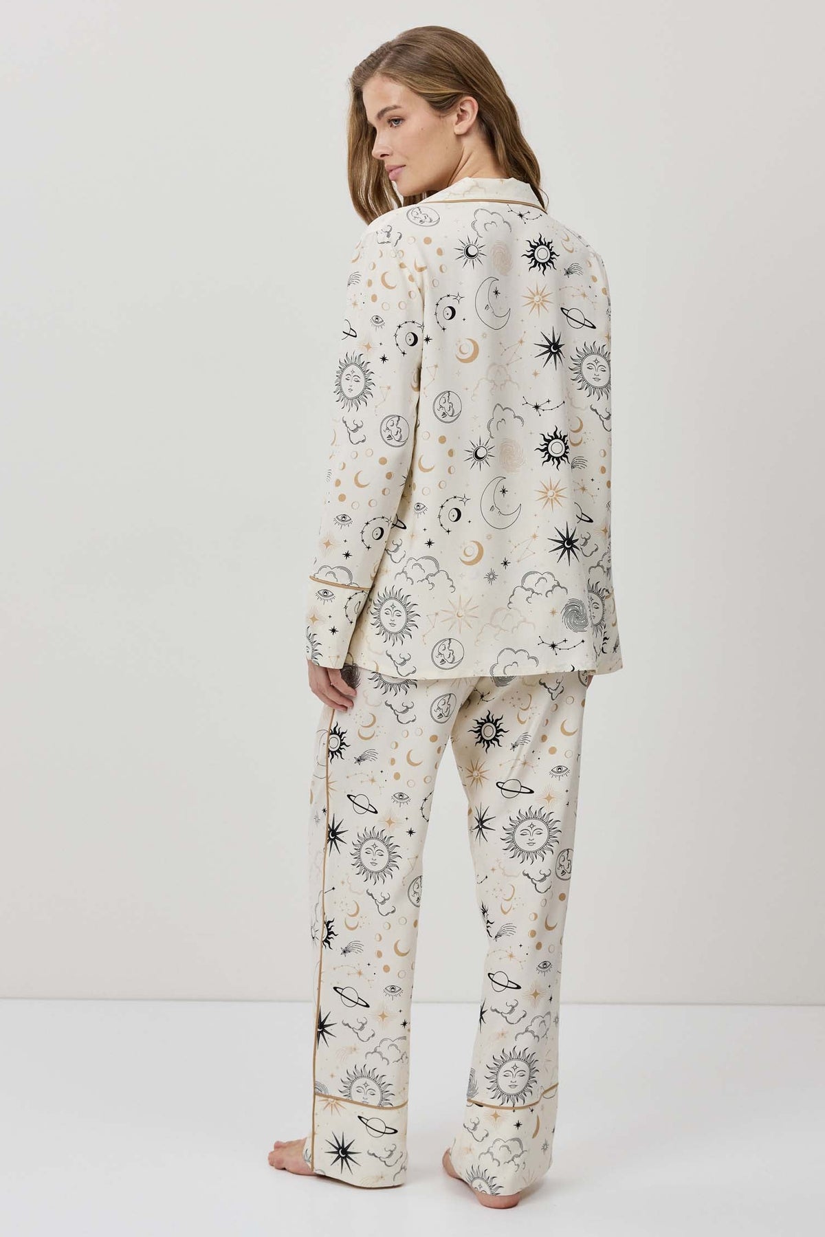 Person wearing a patterned pajama set on a white background