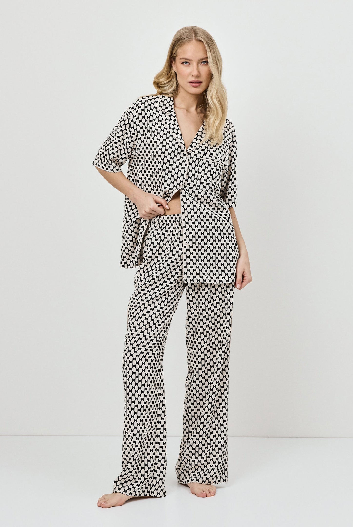 Woman wearing a patterned pajama set on a white background