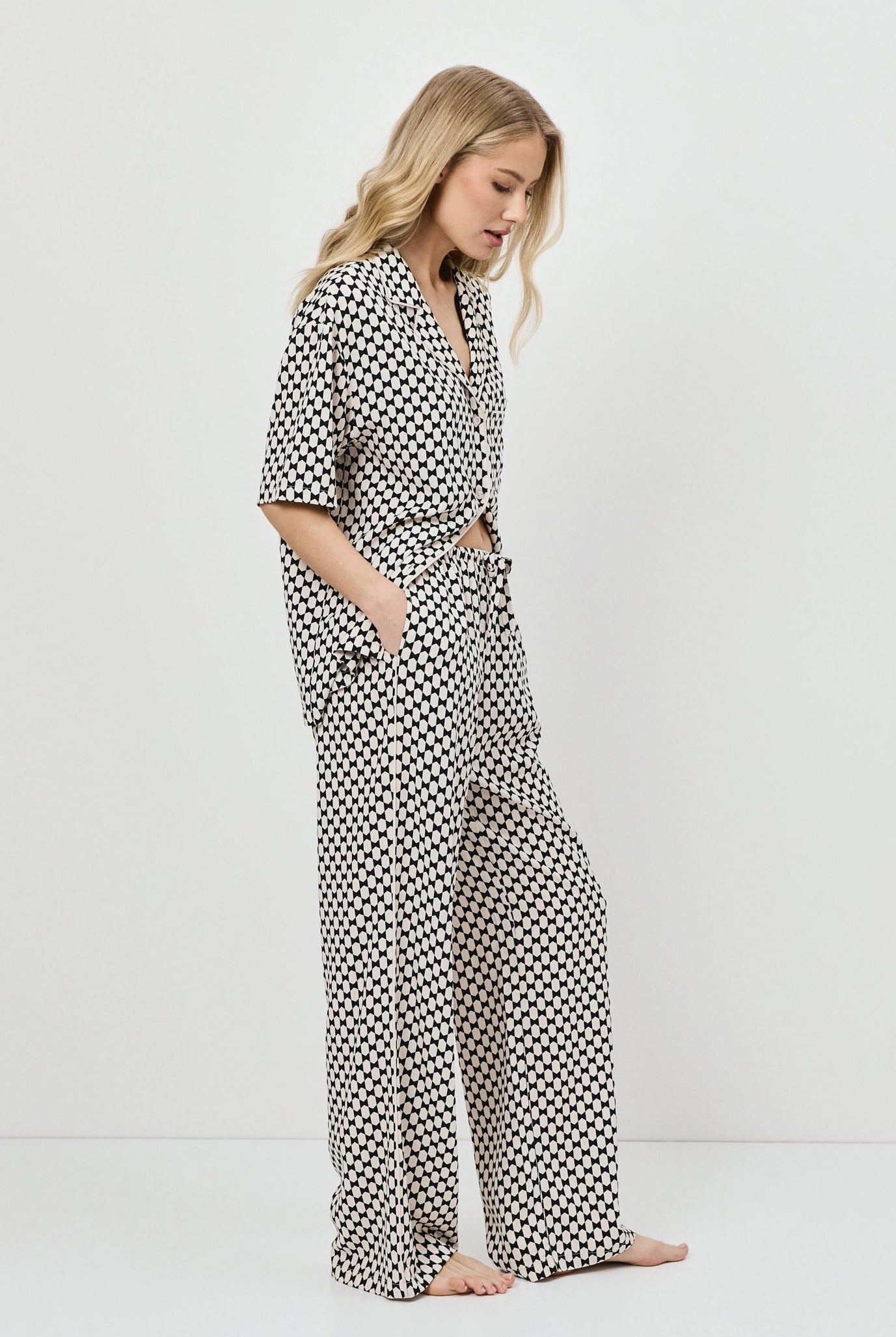 Woman wearing a patterned pajama set on a white background
