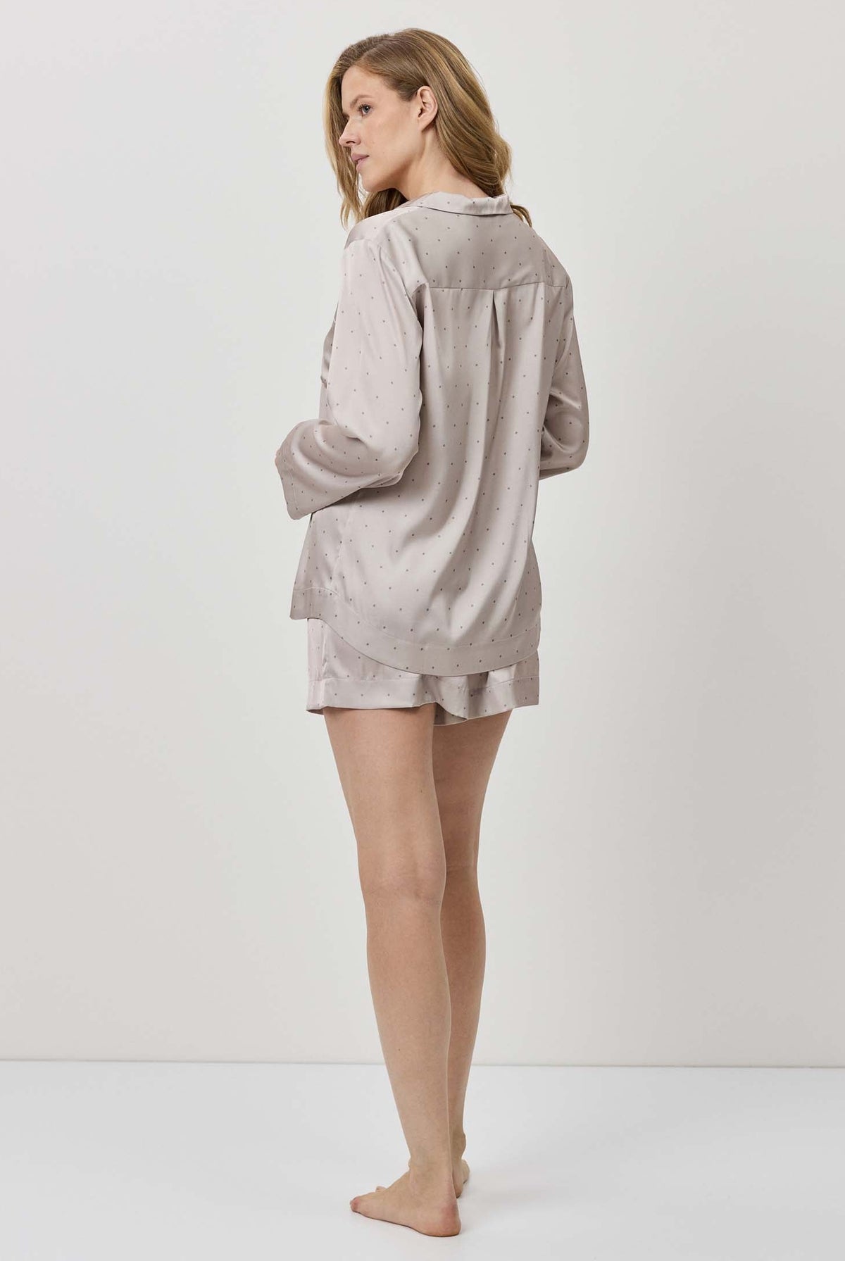Woman wearing a light gray loungewear set on a white background