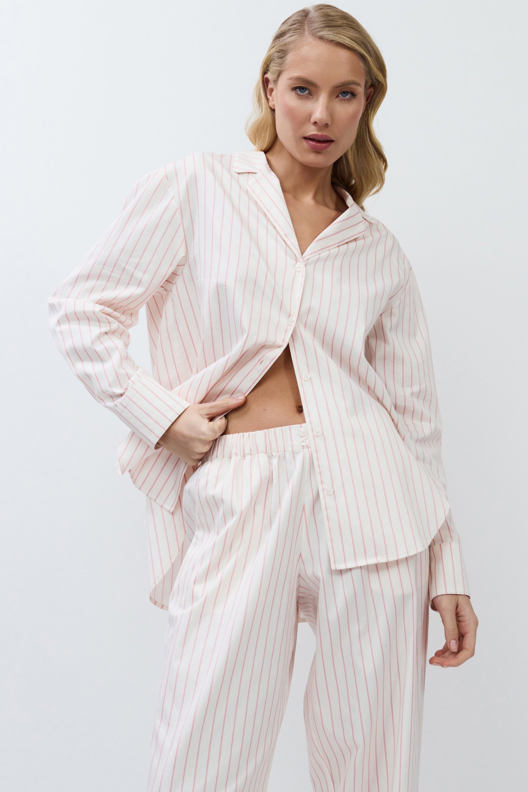 Woman wearing a striped pajama set against a white background