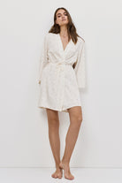 Woman wearing a white gown against a white background