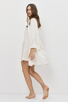 Woman wearing a white nightgown on a plain background