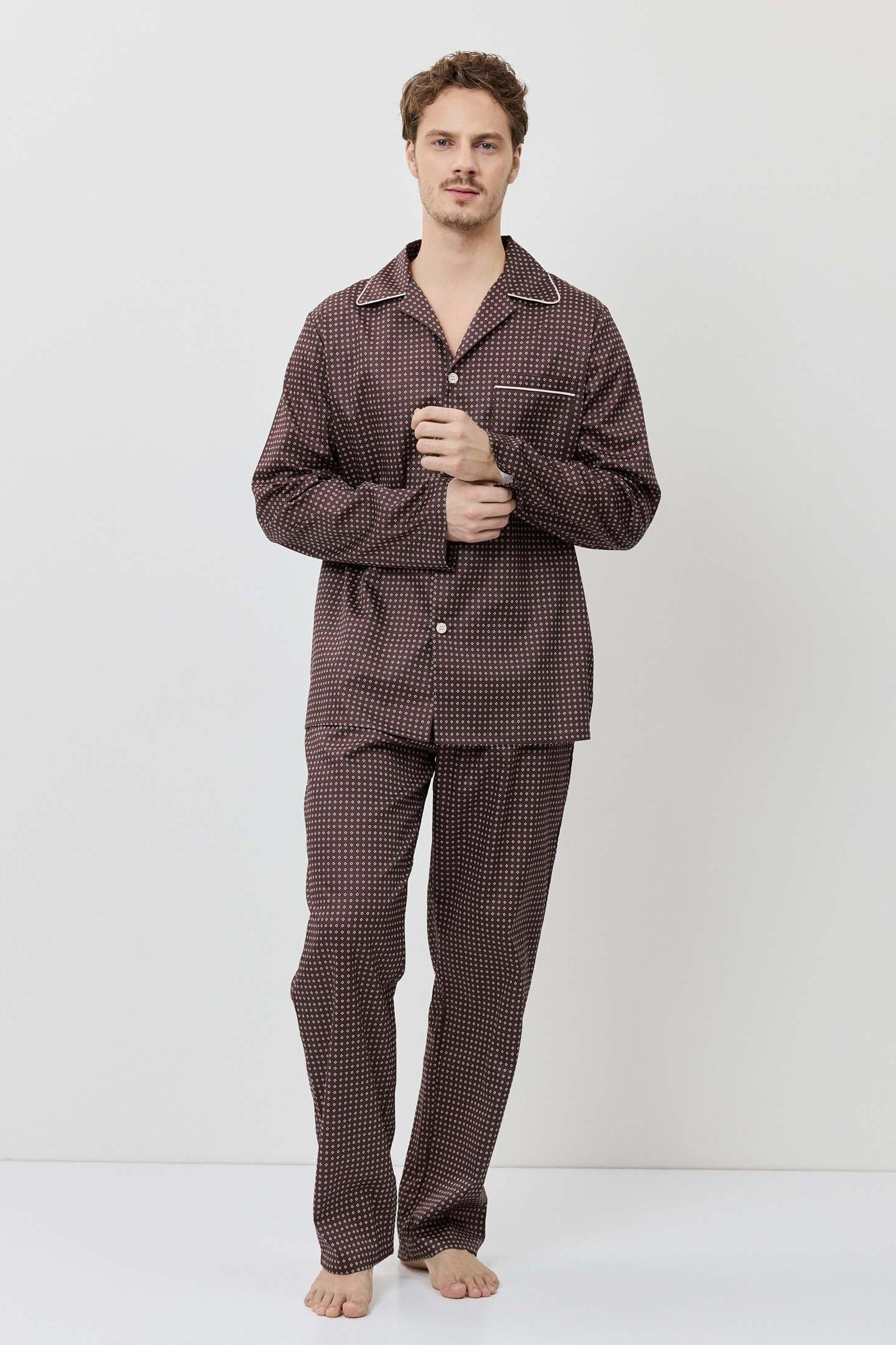 Man wearing a brown checkered pajama set against a white background