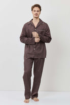 Man wearing a brown checkered pajama set against a white background