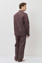 Man wearing a brown checkered pajama set against a white background