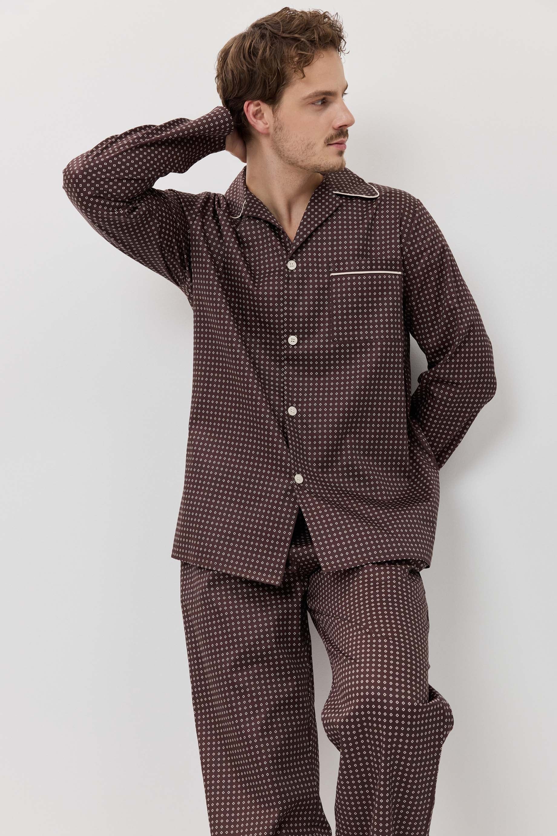 Man wearing a brown checkered pajama set against a white background