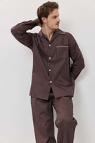 Man wearing a brown checkered pajama set against a white background