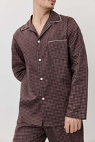 Person wearing a patterned pajama set against a plain background
