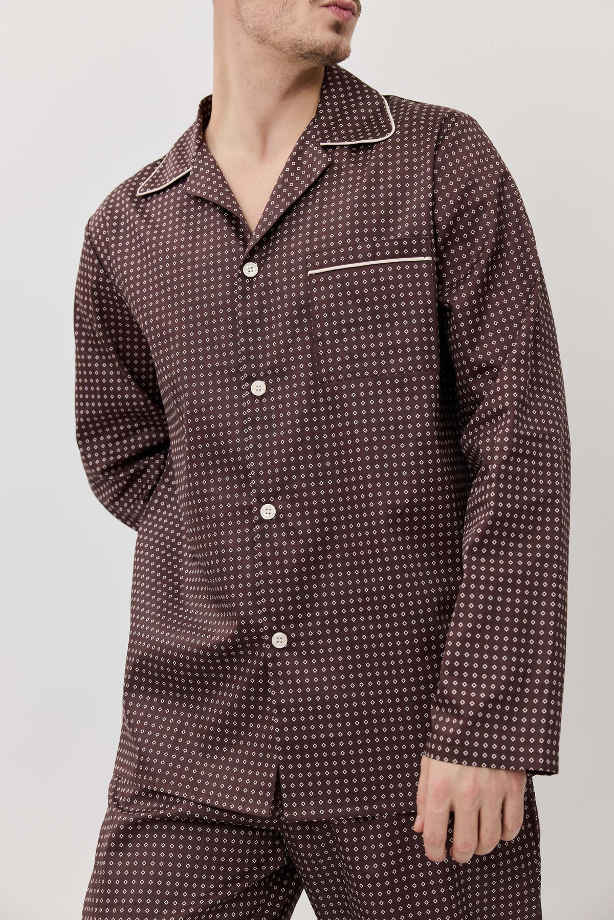 Person wearing a patterned pajama set against a plain background