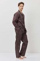 Man wearing a brown checkered pajama set on a white background