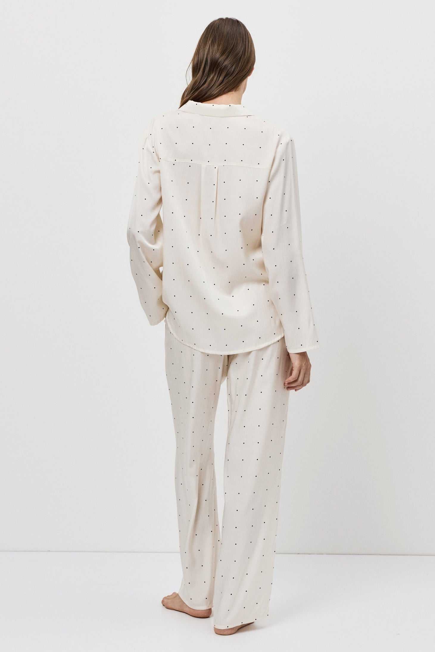 Person wearing a white pajama set standing against a plain white background