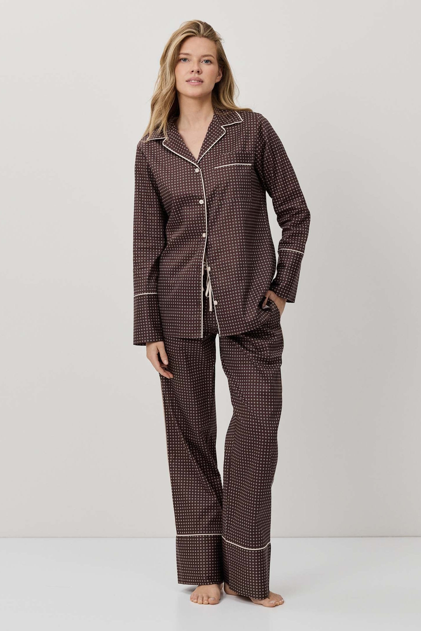 Woman wearing a brown checkered pajama set on a white background